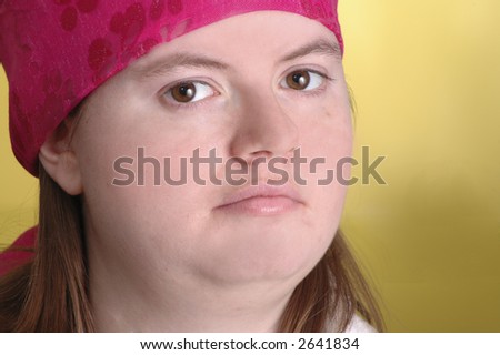 A woman wearing a pink scarf on her head. Yellow background.