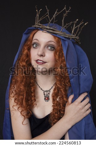 Beautiful red haired woman wearing twig crown and blue velvet dress