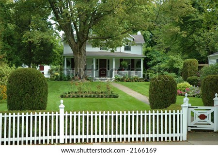 Quaint beautiful house with green yard and white picket fence