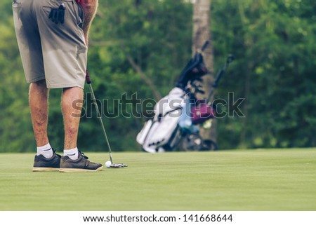 PATTAYA, THAILAND - MAY 29: Unidentified senior man addressing the ball on green at 4th hole at Green Valley St Andrews golf course on May 29, 2013. Pattaya has 25 golf courses close to the city.