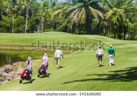 PATTAYA, THAILAND - MAY 29: Unidentified men and caddies in fairway to 4th hole at Green Valley St Andrews golf course on May 29, 2013. Pattaya has 25 golf courses close to the city.