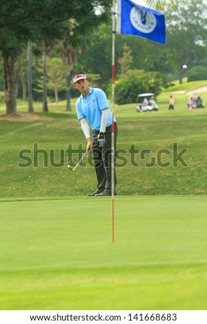PATTAYA, THAILAND - MAY 29: Unidentified asian man pitching to green on 8th hole on Green Valley St Andrews golf course on May 29, 2013. Pattaya has 25 golf courses close to the city.