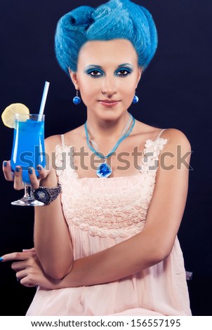 Beautiful girl with blue hair drinking a cocktail \