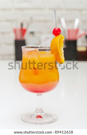Alcoholic cocktail with a cherry on the table in the cafe