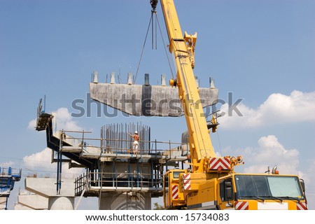 Crane lifting a metal frame to place it on pillar