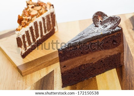 chocolate cake and crispy almond cake on wood board