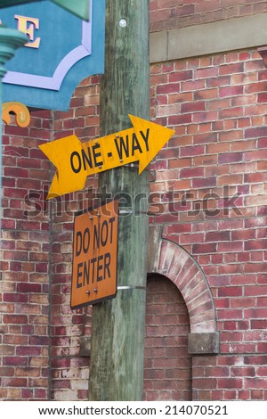 direction sign, one way, do not enter, on wooden pole at alley
