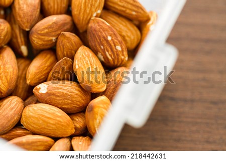 group of almonds in box on wood background