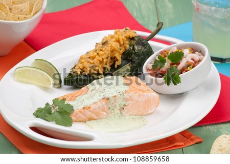 Grilled salmon with achiote rice-stuffed chiles, prawn salsa, and cilantro - jalapeno creme. Served with Margarita cocktail.