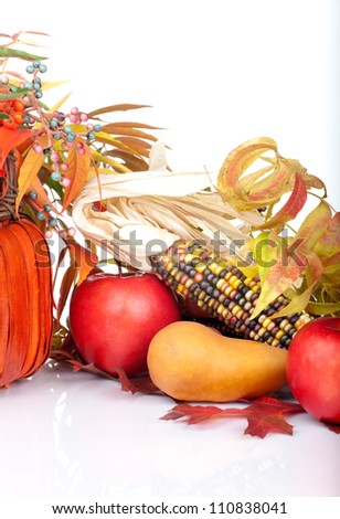 Closeup of multi colored pumpkins, fall beries and leaves as a decoration for Thanksgiving.