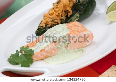 Grilled salmon with achiote rice-stuffed chiles, prawn salsa, and cilantro - jalapeno creme. Served with Margarita cocktail.