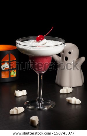 Closeup of Raspberry Vanilla Daiquiri cocktail, garnished with maraschino cherry. Rum, raspberry, liqueur, and lime juice over black background. Halloween drinks series