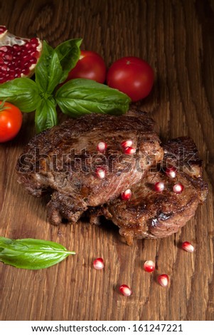 Pan seared beef steaks with fresh tomatoes, basil, and pomegranate.