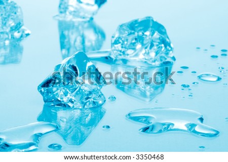 Azure colored ice cubes melted in water on reflection surface ready to be added to a cocktail