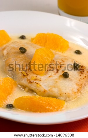 Closeup of grilled skate (ray) with orange and caper sauce.