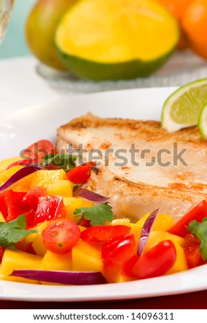 Closeup of fried skate (ray) with mango, cherry tomato and red onion salsa.