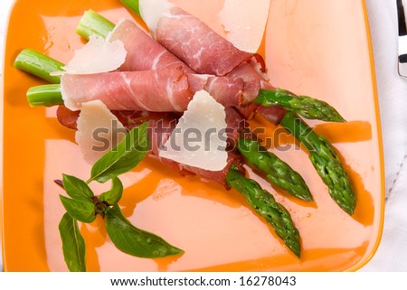 Crispy asparagus wrapped in fresh prosciutto and parmesan cheese is ready to serve