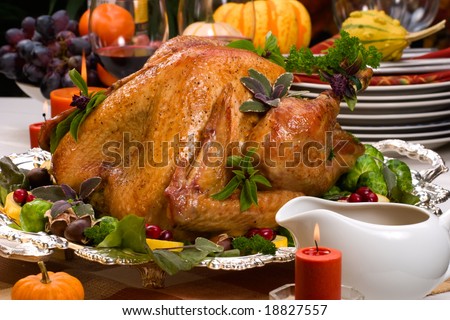 Garnished roasted turkey on Christmas decorated table with candles and flutes of champagne