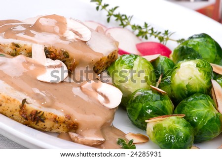 Delicious sliced garlic thyme roast pork loin with mushrooms sauce, brussels sprouts, almonds and radish ready for dinner.