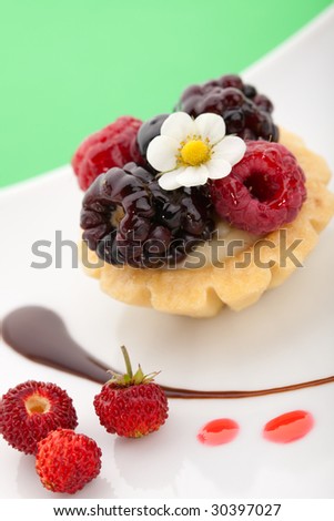 Closeup of delicious berry cake garnished with fresh wild strawberries