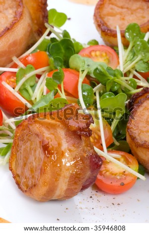 Closeup of Ginger Soy Scallops wrapped by bacon garnished with fresh cherry tomatoes and daikon sprouts.