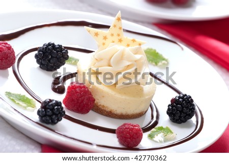 Delicious Vanilla Bean Cheesecake served with fresh raspberries, blackberries and mint.