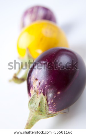 Fresh multi colored mini eggplants in row