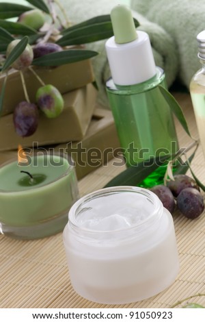 Fancy face cream  with olive soap bars, olive oil, and scented candles for spa treatment