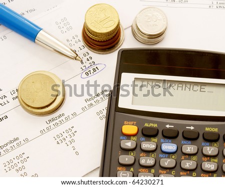 A table full of bills with a pen, some coins and a calculator that displays the word insurance