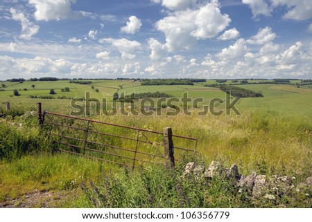 Rolling downs landscape with old farm gate, Cotswolds, England