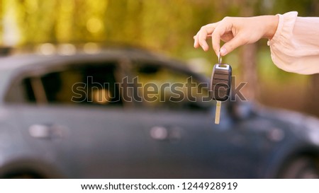 Young woman in car. Ride instruction. Automobile loan. Hand with key.