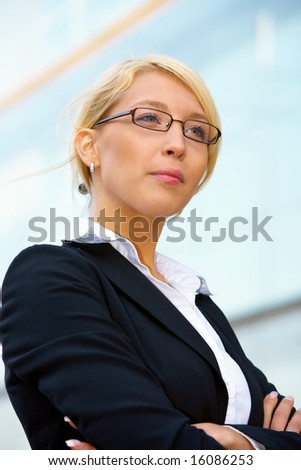 Young businesswoman contemplating outside office building