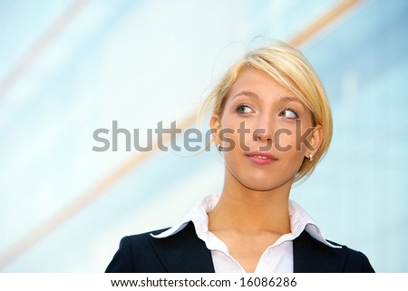 Young businesswoman looking left outside office building