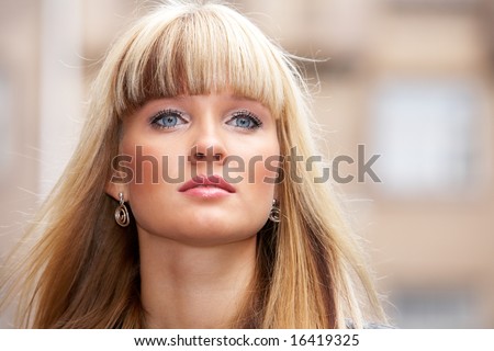 Close-up of young woman standing in city, looking away