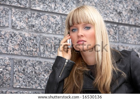 Young woman using mobile phone, looking at camera