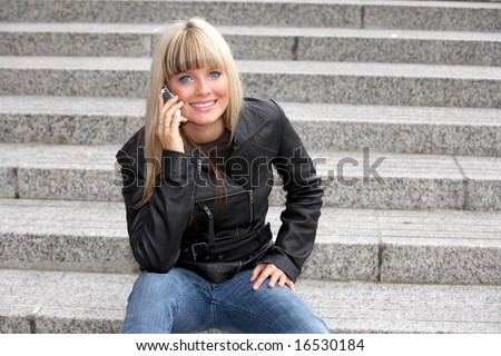 Young woman with mobile phone, looking at camera, smiling