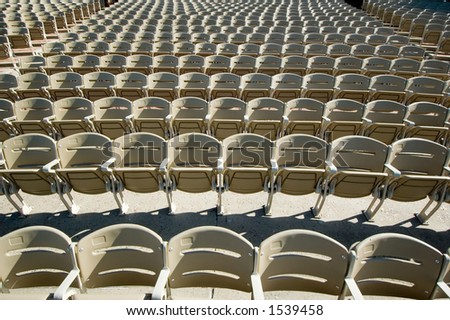 Over one hundred chairs in an outdoor concert hall seen via wide angle perspective