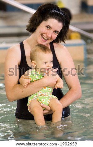 Mother and daughter enjoying baby's first swim lesson.