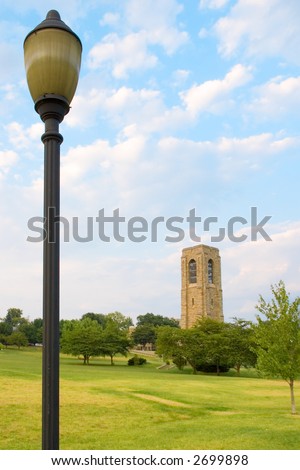 Juxtaposition composed of a small (but large by forced perspective) modern street lamp towering above a 200 year old bell tower in the distance which offset each other and provide draw for the eye.