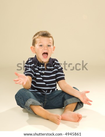 Funny expression on a pre-school aged boy. Arms out and palms gesturing, combined with wide open mouth giving an exuberant or impatient expression.