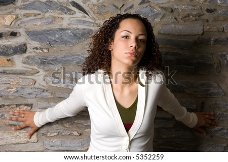 Attractive young woman in a powerful pose making direct eye contact with the viewer and an expression that conveys confidence and power.