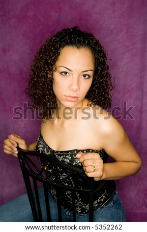 Beautiful young African American fashion model posed against a rich purple colored muslin background. Ring flash lighting accentuates skin tones and contours.