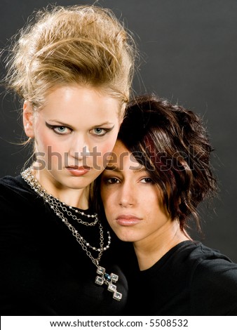 Two beautiful young women in punk, gothic make-up, posed for a portrait making direct eye contact with the viewer.