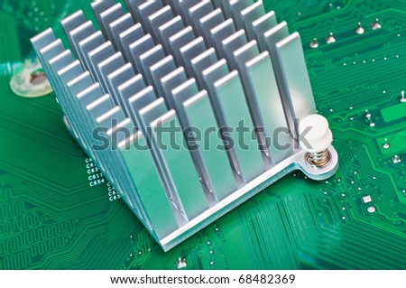 Close-up of an aluminum heatsink mounted on a green computer circuit board