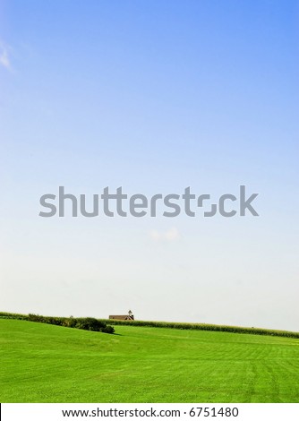 Green field with school-house in distance