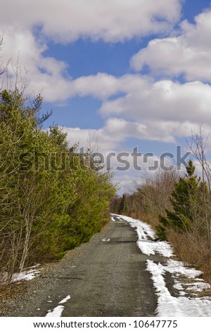 Winter gravel path under blue sky with clouds (BLT trail in Halifax, Nova Scotia)