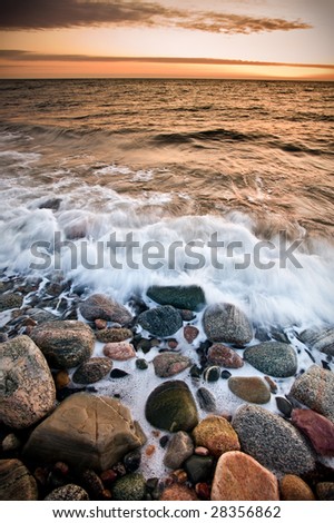 Waves wash ashore during a beautiful sunset. Taken at Gros Morne national park in Canada, which is a UNESCO world heritage site.