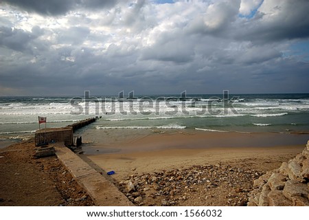 wide photo of a beach with cloudy sky