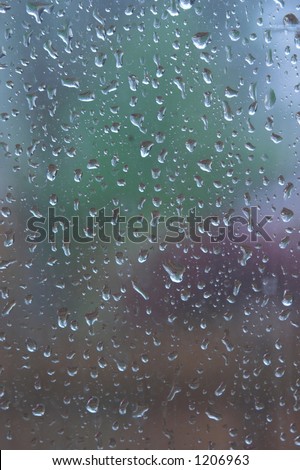 rain drops on window panes evenly distributed with out of focus colorful shapes in background