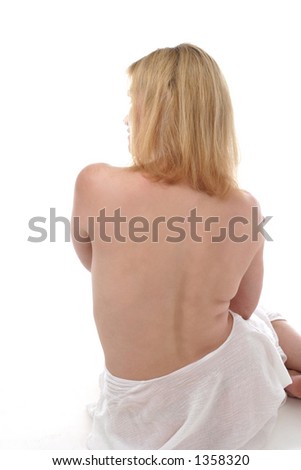Bare back of beautiful blonde woman wrapped in towel ready for the bath